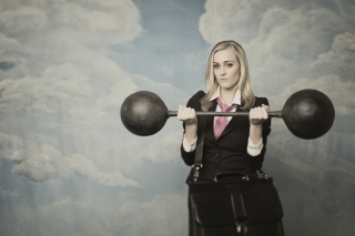 Businesswoman with dumbbell 