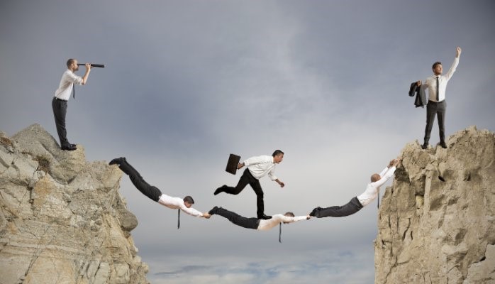 Businessman crossing a cliff